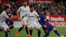 Lionel Messi (vpravo) uniká hráčům Sevilly.