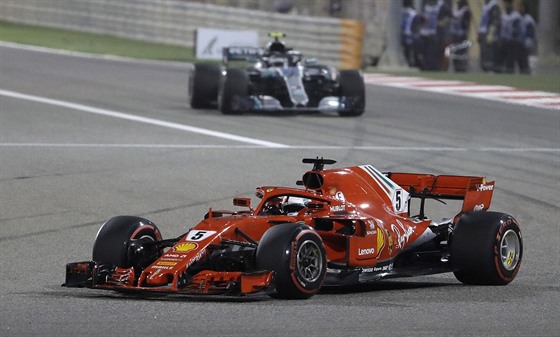 Sebastian Vettel z Ferrari (v popředí) ujíždí Valtterimu Bottasovi z Mercedesu.
