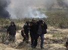 Palestintí demonstranti odvádjí zranného mue ze zóny, kam  izraelské...