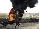Palestinský demonstrant vrhá kameny na izraelské jednotky bhem protestu na...