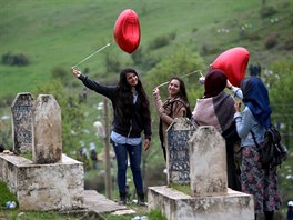 HŘBITOVNÍ SNÍMEK. Ženy s nafukovacími balónky se fotí u náhrobku islámského...