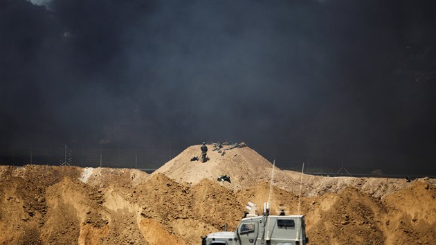 Černý kouř stoupá z hořících pneumatik, které Palestinci pálí v hraničním pásmu Gazy. (6. dubna 2018)