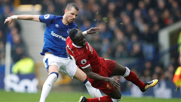 Sadio Mané z Liverpoolu padá na trávník po kontaktu s Morganem Schneiderlinem z Evertonu.