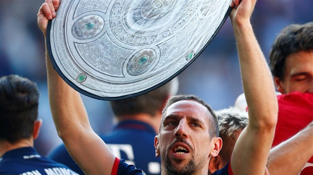 Záložník mnichovského Bayernu Franck Ribéry slaví titul s maketou mistrovské trofeje.