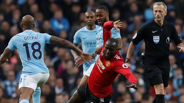 Romelu Lukaku z Manchesteru United padá po souboji s Raheemem Sterlingem z Manchesteru City.