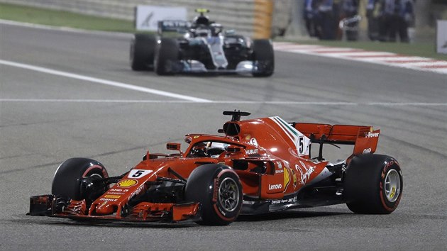 Sebastian Vettel z Ferrari (v poped) ujd Valtterimu Bottasovi z Mercedesu.