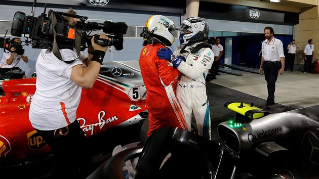 Sebastian Vettel (v ervenm) a Valtteri Bottas si gratuluj v cli Velk ceny Bahrajnu.