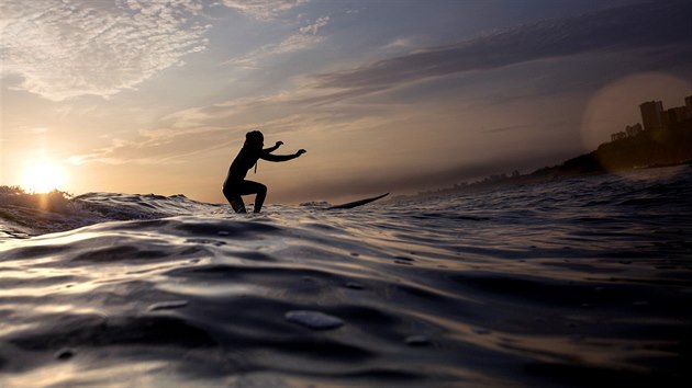 VEERN SURFING. Surfaka sjd vlnu pi zpadu slunce v perunsk Lim.