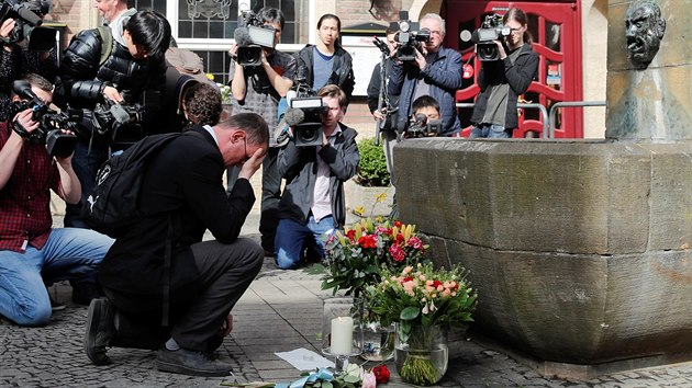Lidé přinášeji květiny a svíčky k soše obchodníka (Kiepenkerl) nedaleko místa útoku v centru Münsteru.(8.4.2018)