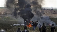 erný kou stoupá z hoících pneumatik, které Palestinci pálí v hraniním pásmu...