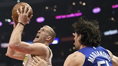 Mason Plumlee (vlevo) z Denveru útoí na ko LA Clippers kolem Bobana...