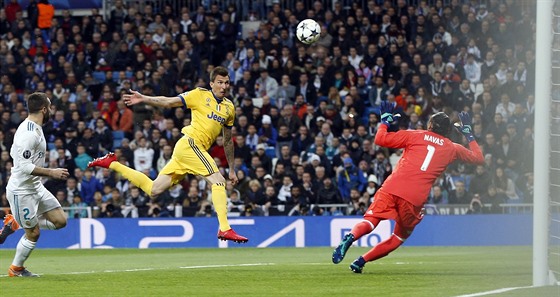 Chorvatský útočník Mario Mandžukič z Juventusu (uprostřed)  hlavou překonává...