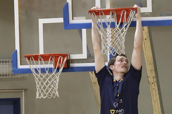 Opavský basketbalista Kryštof Vlček se při rozcvičení houpe na obroučce.