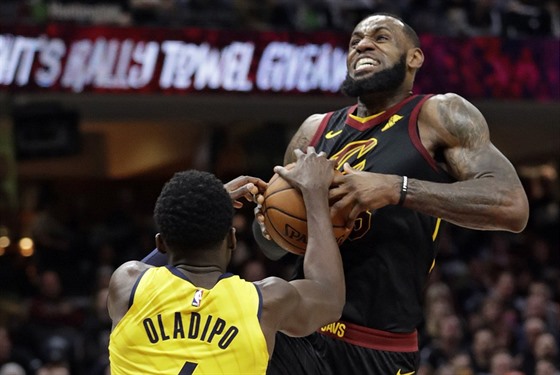 LeBron James (vpravo) z Clevelandu jde na sílu do souboje s Victorem Oladipem z...