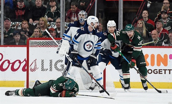 Eric Staal z Minnesoty leí na led po neetrném faulu v utkání s Winnipegem.