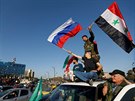 Syané v sobotu ráno v Damaku mávají syrskými a ruskými  vlajkami na protest...