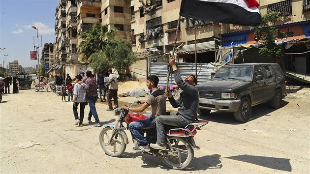 Syrt mui projdj na motocyklu s nrodn vlajkou pot, co syrsk policejn jednotky vstoupily do msta Dma. (14. dubna 2018)