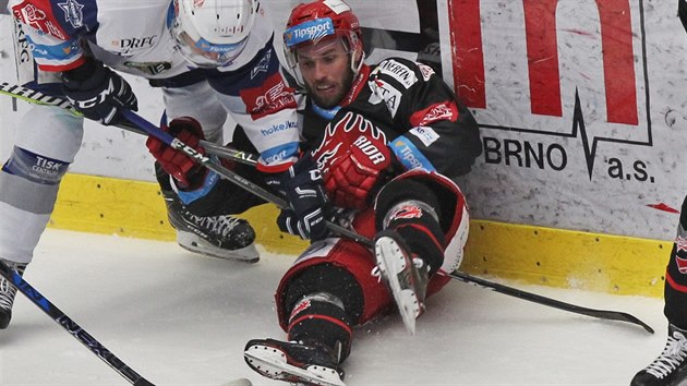 Třinecký Vladimír Svačina (v černém) skončil po tvrdém ataku protihráče na ledě.