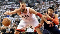 Jonas Valan�iunas (vlevo) z Toronta krotí mí�, atakuje ho Otto Porter z...
