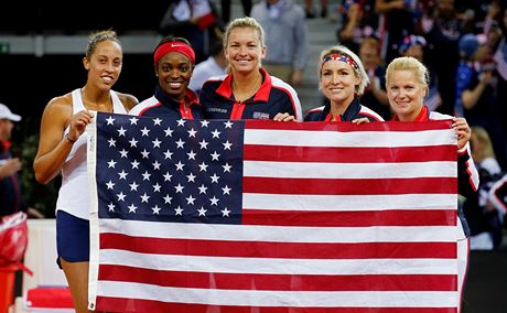 Madison Keys (vlevo) drí vlajku se svým spoluhrákami a trenérkou Kathy...