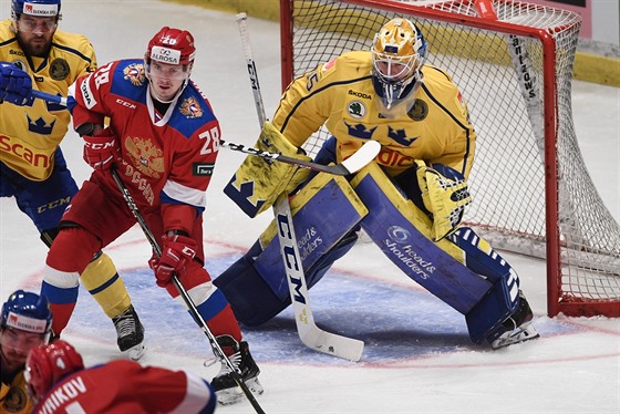 Ruský hokejista Alexej Byvaltsev (v erveném) cloní ped brankáem védska...