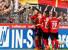 Fotbalisté Freiburgu slaví s fanouky branku v duelu s Kölnem.