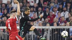 Cristiano Ronaldo z Realu Madrid pálí pes stopera Süleho z Bayernu na bránu....