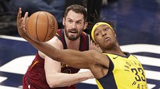 Myles Turner (vpravo) z Indiany stahuje mí ped zraky Kevina Lovea z...