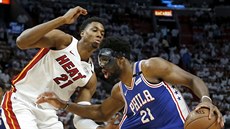 Joel Embiid (vpravo) z Philadelphie útoí kolem Hassana Whitesidea z Miami.