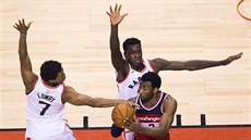 Kyle Lowry (vlevo) a Pascal Siakam (uprosted) z Toronta brání Johna Walla z...