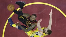 LeBron James (vlevo) z Clevelandu zakonuje pes Domantase Sabonise z Indiany.