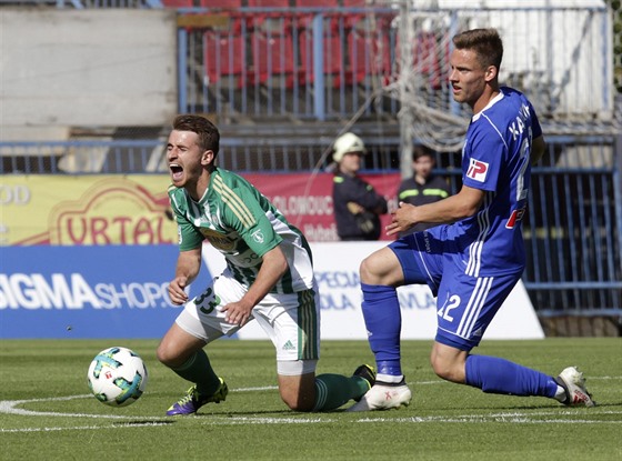 Záloník Bohemians Dominik Maek padá k zemi po zákroku Lukáe Kalvacha z...