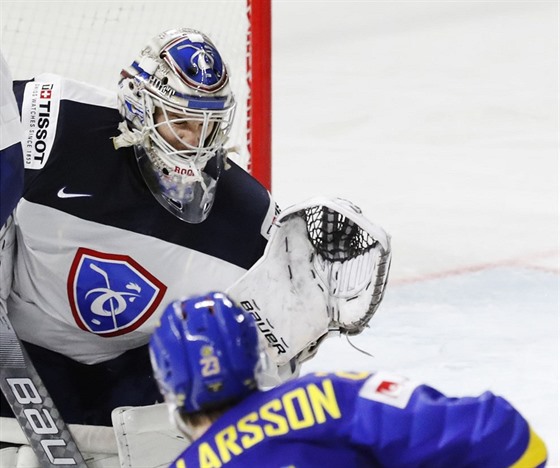 védský obránce Oliver Ekman Larsson pekonává francouzského gólmana Ronana...