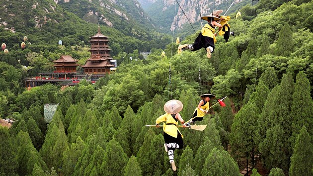 AKROBATI. Studenti šaolinské školy kung-fu zavěšení na lanech nacvičují noční...