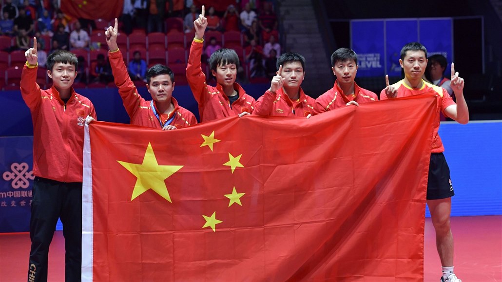 Čínští stolní tenisté oslavují vítězství na mistrovství světa.