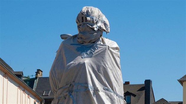 Zabalená socha Karla Marxe na náměstí v německém Trevíru čeká na odhalení. (4. května 2018)