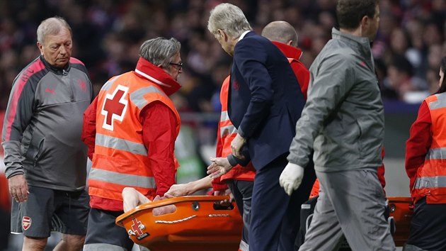 DRŽ SE. Trenér Arsenalu Arséne Wenger utěšuje obránce Laurenta Koscielného, který kvůli zranění nedohrál odvetný souboj semifinále Evropské ligy proti Atlétiku Madrid.