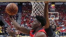 Jrue Holiday (v erveném) z New Orleans zakonuje na ko Golden State kolem...