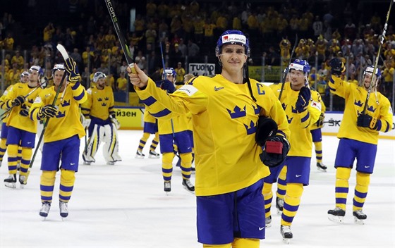 védský kapitán Mikael Backlund slaví se spoluhrái postup do finále MS.