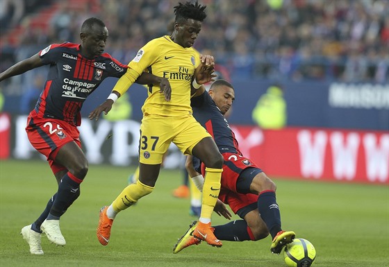 Timothy Weah z PSG (ve lutém) se snaí vymanit z obklíení protihrá z Caen.