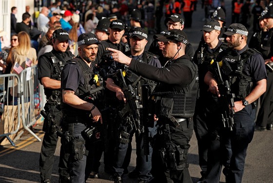 Policisté vyzbrojení automatickými zbranmi se domlouvají na zajitní...