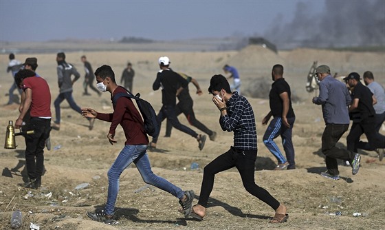 Palestintí demonstranti se utíkají schovat ped slzným plynem (15. kvtna...