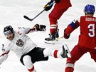 Rakouský hokejista Thomas Hundertpfund padá po stetu s Radko Gudasem.
