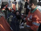 Palestinští demonstranti se snaží naložit zraněnou ženu na nosítka (15. května...