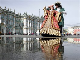 MASKY. Pouliční herci oblečení do kostýmů z 18. století tančí na náměstí...