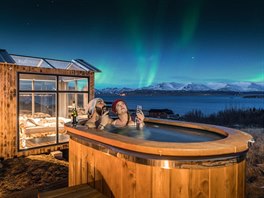 Příbytek Panorama Glass Lodge stojí na Islandu. Stěny a střecha ložnice jsou...