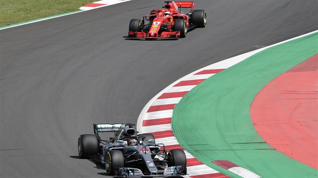 Brit Lewis Hamilton s šedým vozem Mercedes ujíždí na Velké ceně Španělska Němci Sebastianu Vettelovi.