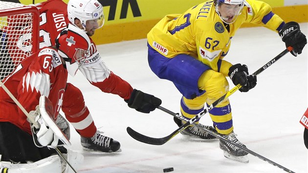 Rickard Rakell ze �v�dska (ve �lut�m) man�vruje p�ed �v�carskou brankou.