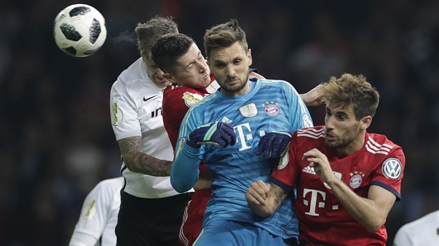 Brankář Bayernu Sven Ulreich (v modrém) vyrazil ve finále Německého poháru likvidovat centrovaný míč.