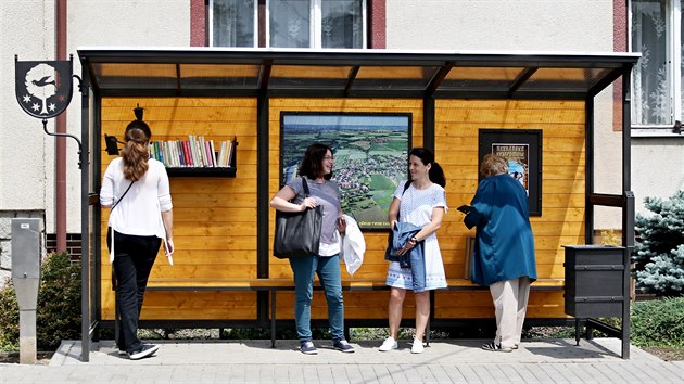 Zastvka v Rajhradicch na Brnnsku od umleckho kove Zdeka Mittnera m krom laviky k sezen tak polici s knihami a schrnku na nedopalky umstnou nad odpadkovm koem.